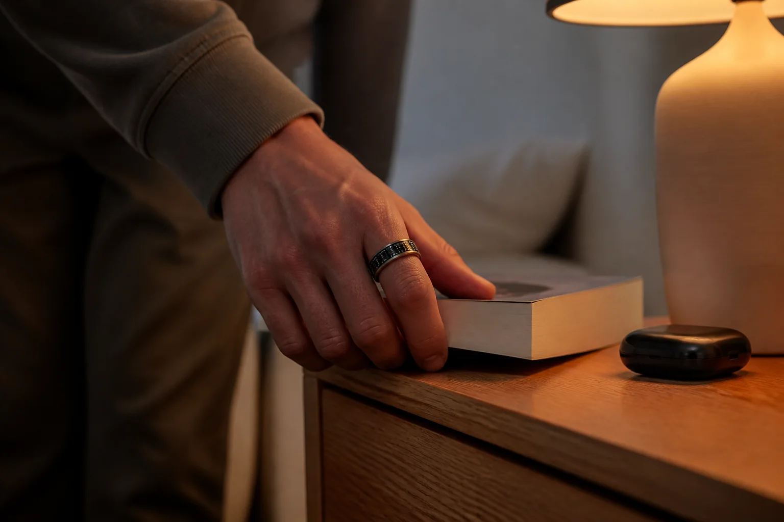A SAYDIAN R7 smart ring worn beside a bedside table